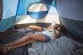 Happy woman using digital tablet while lying down in tent Royalty Free Stock Photo
