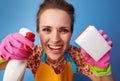 Happy woman using kitchen sponge and cleaning detergent on blue Royalty Free Stock Photo