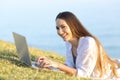Happy woman using a laptop on the grass looking at you Royalty Free Stock Photo