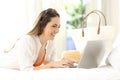 Woman using a laptop on a bed on summer vacations Royalty Free Stock Photo