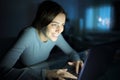 Happy woman using laptop typing in the night at home Royalty Free Stock Photo