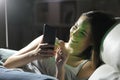 Happy woman using phone in the sofa at night at home Royalty Free Stock Photo