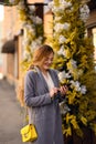Happy woman using a smart phone in the street with an unfocused background. Trend of the year yellow gray