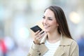 Happy woman using voice recognition on cell phone