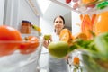 Happy Woman With Vegetables In Front Of Open Refrigerator. concept of healthy eating at home Royalty Free Stock Photo