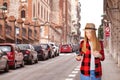 Happy woman walking and using a smart phone on a city street. Royalty Free Stock Photo