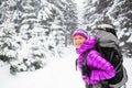 Happy woman walking in winter forest with backpack Royalty Free Stock Photo