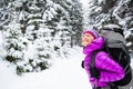 Happy woman walking in winter forest with backpack Royalty Free Stock Photo