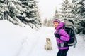 Happy woman walking in winter forest with dog Royalty Free Stock Photo