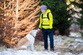 Happy woman walking in winter forest with dog Royalty Free Stock Photo