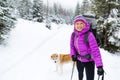 Happy woman walking in winter forest with dog Royalty Free Stock Photo