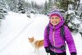 Happy woman walking in winter forest with dog Royalty Free Stock Photo