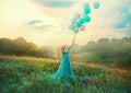 Happy woman walks in blooming valley. Fantasy girl princess holding in hand ball air balloon. long blue tulle fashion