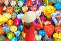 Happy woman wearing Ao Dai Vietnamese dress with colorful lanterns, traveler sightseeing at Hoi An ancient town in central Vietnam Royalty Free Stock Photo