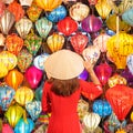 happy woman wearing Ao Dai Vietnamese dress with colorful lanterns, traveler sightseeing at Hoi An ancient town in central Vietnam Royalty Free Stock Photo