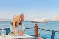 woman wearing big hat sitting in cafe and looking to the seascape Royalty Free Stock Photo