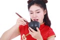 Woman wearing chinese cheongsam dress with chopsticks and bowl i Royalty Free Stock Photo