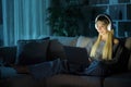 Happy woman wearing headphone using computer in the night Royalty Free Stock Photo