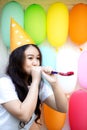 Cute women wearing party hat cheering and celebrating blowing party horn. Funny lovely girl blowing in party whistle and copy spa Royalty Free Stock Photo