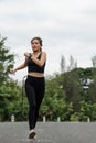 Happy woman wearing sportswear jogging in the park. Young beautiful asian female in sports bra running outdoor. Workout Royalty Free Stock Photo