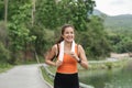 Happy woman wearing sportswear jogging in the park. Young beautiful asian female in sports bra running outdoor. Workout Royalty Free Stock Photo