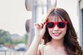 Happy woman wearing sunglasses posing with shopping bags and looking at camera, shopping concept