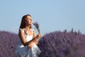 Woman smelling bouquet of lavender flowers in a field Royalty Free Stock Photo