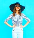 Happy woman wearing a white pants and straw summer hat