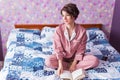 Happy woman wears pajama and relaxing at home and reading a book. Stay home. Quarantine pandemic coronavirus concept. Royalty Free Stock Photo