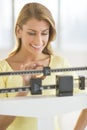 Happy Woman Weighing Herself On Balance Scale Royalty Free Stock Photo