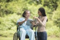 Happy Woman in a wheelchair reading a book with her daughter Royalty Free Stock Photo