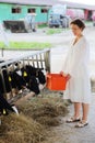 Happy woman in white coat holds container with