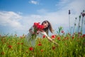 Happy woman in white dress on field of poppies at summer sunset, summer vacation Royalty Free Stock Photo