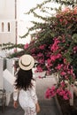 Woman in white dress and straw hat on Santorini island