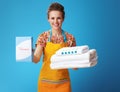 Happy woman with white linen showing powder detergent on blue