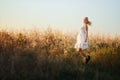 Happy woman in a white summer long dress jumping in front of the cornfield Royalty Free Stock Photo