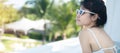 Happy woman in white swimsuit swimming in luxury pool hotel, young female with hat enjoy in tropical resort. Relaxing, summer Royalty Free Stock Photo