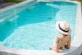 Happy woman in white swimsuit swimming in luxury pool hotel, young female with hat enjoy in tropical resort. Relaxing, summer Royalty Free Stock Photo