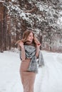 Happy woman on the winter forest background. Young pretty girl in the woods outdoors. Portrait of a cheerful beautiful Royalty Free Stock Photo