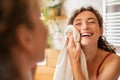 Happy woman wiping face with towel in bathroom Royalty Free Stock Photo