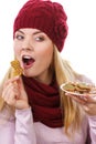Happy woman in woolen cap and shawl eating gingerbread cookies, white background, christmas time Royalty Free Stock Photo