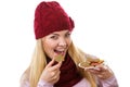 Happy woman in woolen cap and shawl eating gingerbread cookies, white background, christmas time Royalty Free Stock Photo