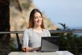 Happy woman working with her laptop in an hotel terrace Royalty Free Stock Photo