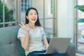 Happy Woman working on laptop in living room at home with ralaxing and smile during quarantine period, for new normal work from