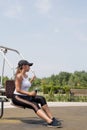 Happy woman working out on the sports ground in sunny summer day, drinking water from the bottle, having rest Royalty Free Stock Photo