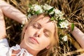 Happy woman in wreath of flowers lying on straw Royalty Free Stock Photo