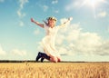 Happy woman in wreath jumping on cereal field Royalty Free Stock Photo