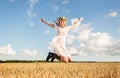 Happy woman in wreath jumping on cereal field Royalty Free Stock Photo