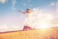 Happy woman in wreath jumping on cereal field Royalty Free Stock Photo