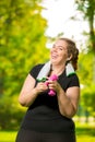 happy woman 30 years old plus size without complexes deals with dumbbells during a workout